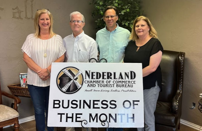 Photo of the legal team standing behind sign that reads "Nederland Business Of The Month."